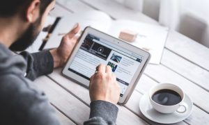 man with tablet interacting with brookscomm marketing content
